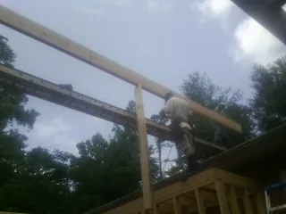 Carpenter setting a ridge beam over a new addition frame — Ice Dam Removal by Roofing Brothers in Cassville