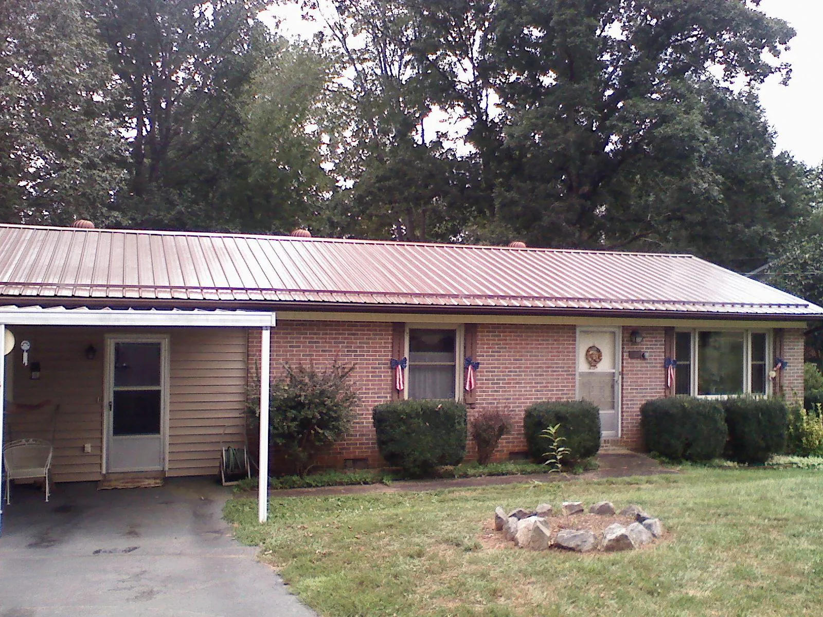 Bronze metal roof and carport on a brick ranch home — Roof Repair work by our crew in Cassville